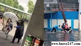 Bảo vệ trường học không ngại trời mưa giúp đỡ sinh viên